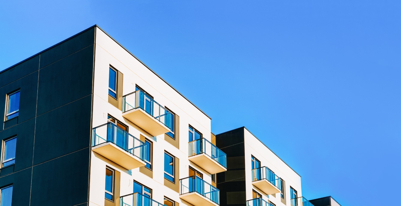 Façade d'immeuble avec balcons vitrés, illustrant l'assistance en performance des bâtiments